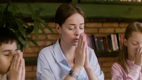 Two-kids-and-a-teacher-praying-in-class