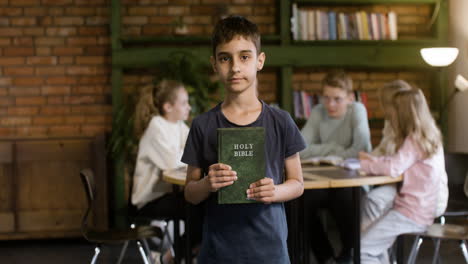 Niño-Sosteniendo-Un-Libro-De-La-Biblia-Verde