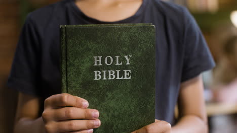 Primer-Plano-De-Un-Joven-Con-La-Santa-Biblia-En-Sus-Manos