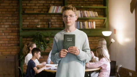 Blond-kid-holding-the-holy-Bible-in-his-hands