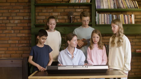 Christliche-Schüler-Singen-Mit-Ihrem-Lehrer-Im-Takt-Des-Keyboards-Und-Der-Ukelele