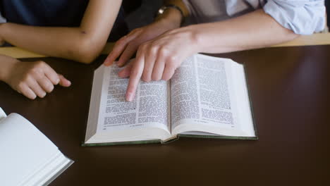 Primer-Plano-De-Un-Maestro-Que-Ayuda-A-Un-Estudiante-Con-El-Estudio-De-La-Biblia