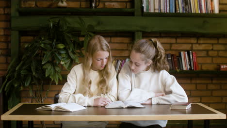 Dos-Chicas-Rubias-Leyendo-La-Biblia-En-La-Escuela