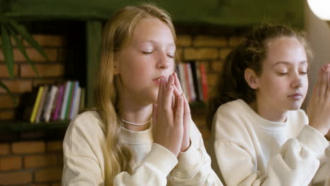 Young-students-praying-together-at-school