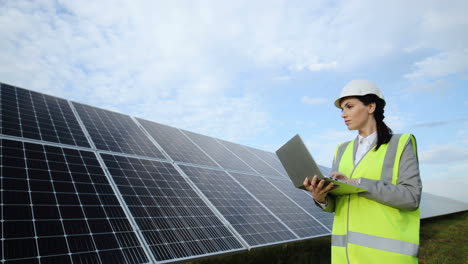 Young-caucasian-woman-engineer-using-laptop-on-solar-panel