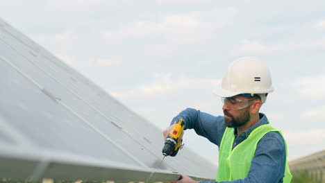 Hombre-Caucásico-Con-Uniforme-Especial-Y-Casco-Protector-Reparando-Un-Panel-Solar