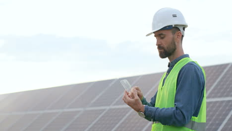 Caucasian-male-engineer-in-protective-helmet-using-a-glass-like-a-tablet-on-a-solar-plantation