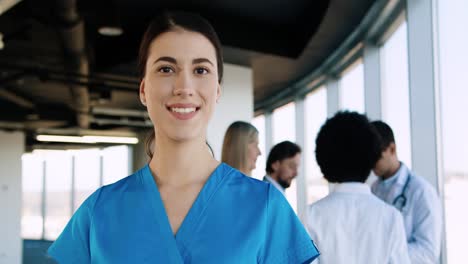Close-up-view-of-cheerful-young-caucasian-nurse-smiling-to-camera-in-good-mood-in-hospital