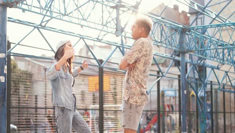 Close-up-view-of-hipster-happy-couple-dancing-and-having-fun-in-the-street