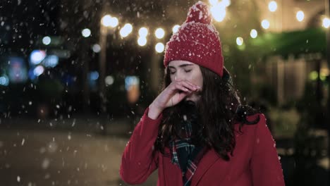Close-up-view-of-Caucasian-woman-in-medical-mask-coughing-on-the-street-while-it¬¥s-snowing-in-Christmas