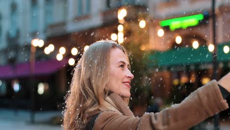 Nahaufnahme-Einer-Kaukasischen-Frau,-Die-Ein-Selfie-Mit-Dem-Smartphone-Auf-Der-Straße-Macht,-Während-Es-In-Weihnachten-Schneit