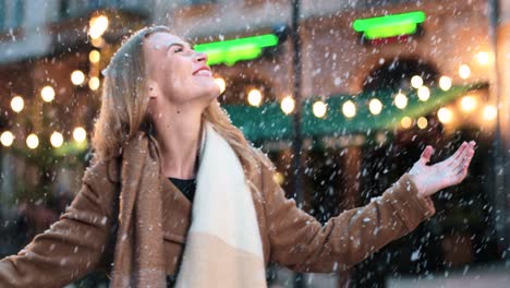 Close-up-view-of-caucasian-woman-spinning-and-smiling-under-snow-on-the-street-in-Christmas