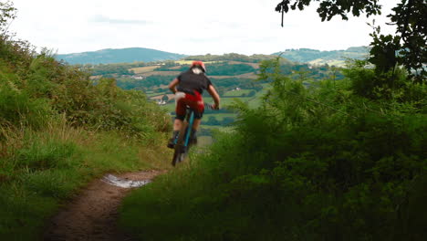 A-mountain-biker-riding-a-trail-in-Wales,-UK