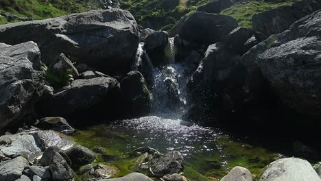 Small-waterfall-in-slow-motion-flowing-into-a-small-lake