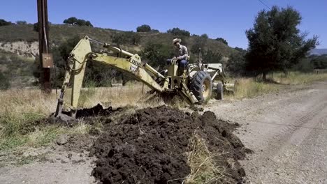 Backhoe-tractor-digging-up-a-leaking-water-line-on-a-hot-day-7