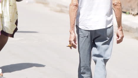 Man-walking-with-cigar-in-hand-on-street-in-Havana-Cuba