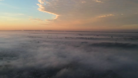 Above-low-clouds-sunrise-with-pylons-coming-out-of-the-mist