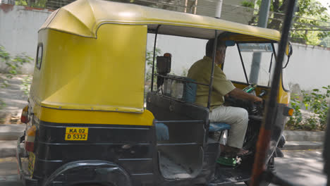 Hombre-Conduciendo-Un-Taxi-Rickshaw-Automático-A-Lo-Largo-De-La-Calle-En-Bangalore,-India