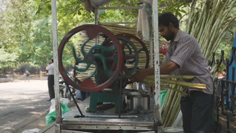 Vendedor-Ambulante-De-Comida-Triturando-Caña-De-Azúcar-En-Bangalore,-India