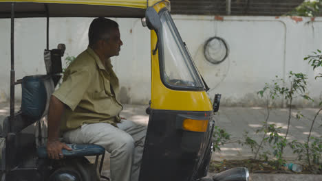 Conductor-Sentado-En-Un-Taxi-Auto-Rickshaw-Estacionado-En-La-Calle-En-Bangalore,-India
