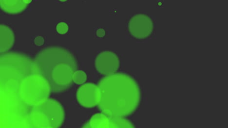 Vibrant-Green-Spheres-In-A-Mysterious-Dance-Against-Black-Space