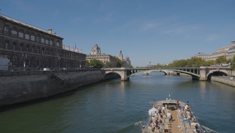 Touristenboot-Fährt-Unter-Der-Brücke-Pont-Notre-Dame-über-Die-Seine-In-Paris,-Frankreich,-Mit-Touristen-Und-Verkehr-1