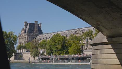 Exterior-Of-Hotel-De-Ville-In-Paris-France-Shot-From-River-Seine-With-Tourist-Boat-In-Slow-Motion