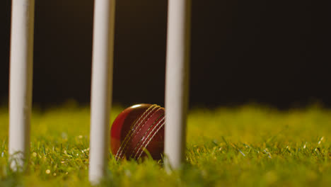 Cricket-Stillleben-Mit-Nahaufnahme-Eines-Balls-Im-Gras-Hinter-Stümpfen