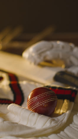 Cricket-Still-Life-With-Close-Up-Of-Bat-Ball-Gloves-Stumps-Jumper-And-Bails-Lying-On-Wooden-Surface-In-Locker-Room-3