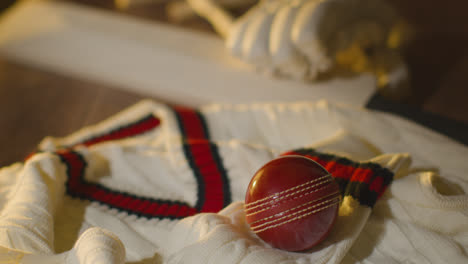 Cricket-Still-Life-With-Close-Up-Of-Bat-Ball-Gloves-Stumps-Jumper-And-Bails-Lying-On-Wooden-Surface-In-Locker-Room-3