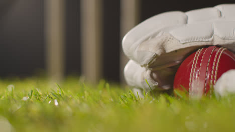 Cricket-Still-Life-With-Close-Up-Of-Ball-Lying-In-Glove-On-Grass-In-Front-Of-Stumps-4