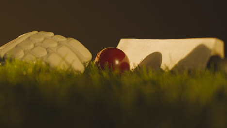 Cricket-Stillleben-Mit-Nahaufnahme-Eines-Schlägerballs-Und-Handschuhen,-Die-Im-Gras-Liegen