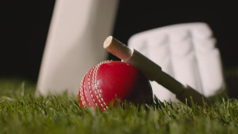 Cricket-Stillleben-Mit-Nahaufnahme-Von-Im-Gras-Liegenden-Schlägerballbügeln-Und-Handschuhen-4