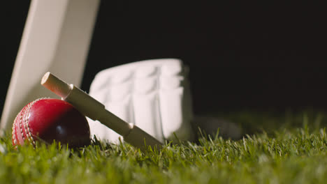 Cricket-Stillleben-Mit-Nahaufnahme-Von-Schlägerballbügeln-Und-Handschuhen,-Die-Im-Gras-Liegen