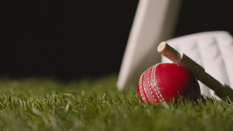 Cricket-Stillleben-Mit-Nahaufnahme-Von-Im-Gras-Liegenden-Schlägerballbügeln-Und-Handschuhen-5