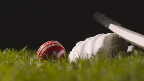 Cricket-Stillleben-Mit-Nahaufnahme-Eines-Im-Gras-Liegenden-Schlägerballs-Und-Handschuhen-1