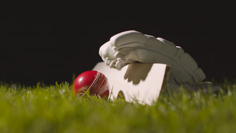 Cricket-Stillleben-Mit-Nahaufnahme-Eines-Im-Gras-Liegenden-Schlägerballs-Und-Handschuhen-4