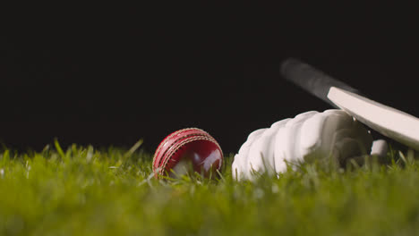 Cricket-Stillleben-Mit-Nahaufnahme-Eines-Im-Gras-Liegenden-Schlägerballs-Und-Handschuhen-2