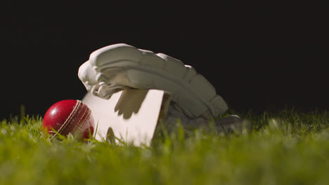 Cricket-Stillleben-Mit-Nahaufnahme-Eines-Im-Gras-Liegenden-Schlägerballs-Und-Handschuhen-3
