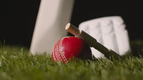 Cricket-Stillleben-Mit-Nahaufnahme-Von-Im-Gras-Liegenden-Schlägerballbügeln-Und-Handschuhen-3