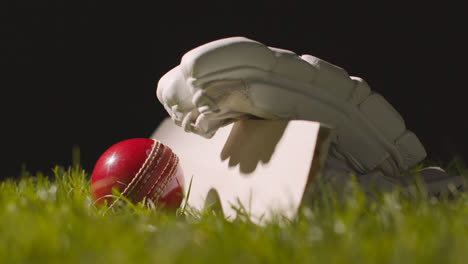 Cricket-Stillleben-Mit-Nahaufnahme-Eines-Im-Gras-Liegenden-Schlägerballs-Und-Handschuhen-5