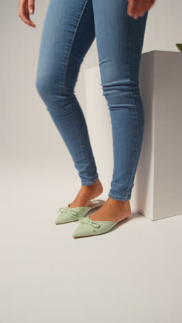 Close-Up-Vertical-Video-Of-Female-Social-Media-Influencer-Producing-User-Generated-Content-Putting-On-Beautiful-Pair-Of-Green-Shoes