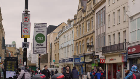 View-Along-Cornmarket-Street-In-City-Centre-Of-Oxford-With-Shops-And-Pedestrians-And-Sign-For-Zero-Emission-Traffic-Zone