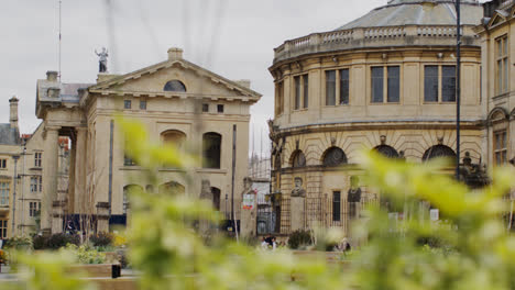 Exterior-Of-Sheldonian-Theatre-Building-In-City-Centre-Of-Oxford-With-Traffic-And-Pedestrians