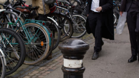 Close-Up-Of-Pedestrians-Walking-Past-Rack-Of-Bikes-Outside-College-In-City-Centre-Of-Oxford-2