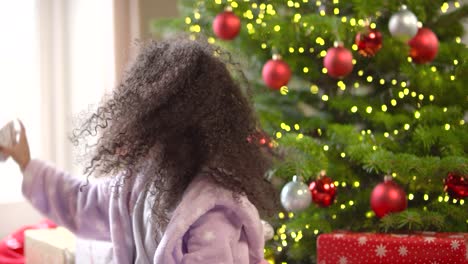 Niño-agarrando-y-sacudiendo-el-regalo-de-Navidad