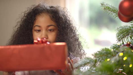 Inquisitive-Niño-Holding-Christmas-Present