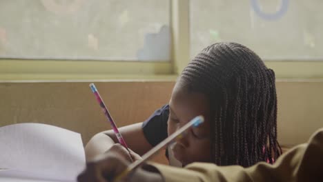 Young-African-Girl-Writing-in-Classroom