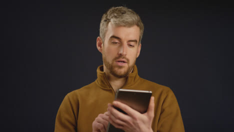 Hombre-mirando-su-tableta-frente-a-la-cámara