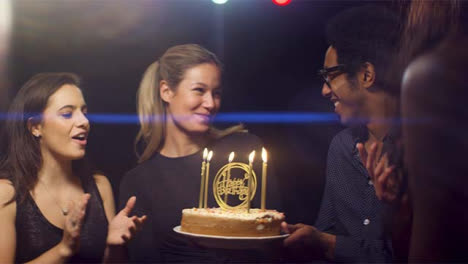 Happy-Woman-Blows-Out-Birthday-Cake-Candles